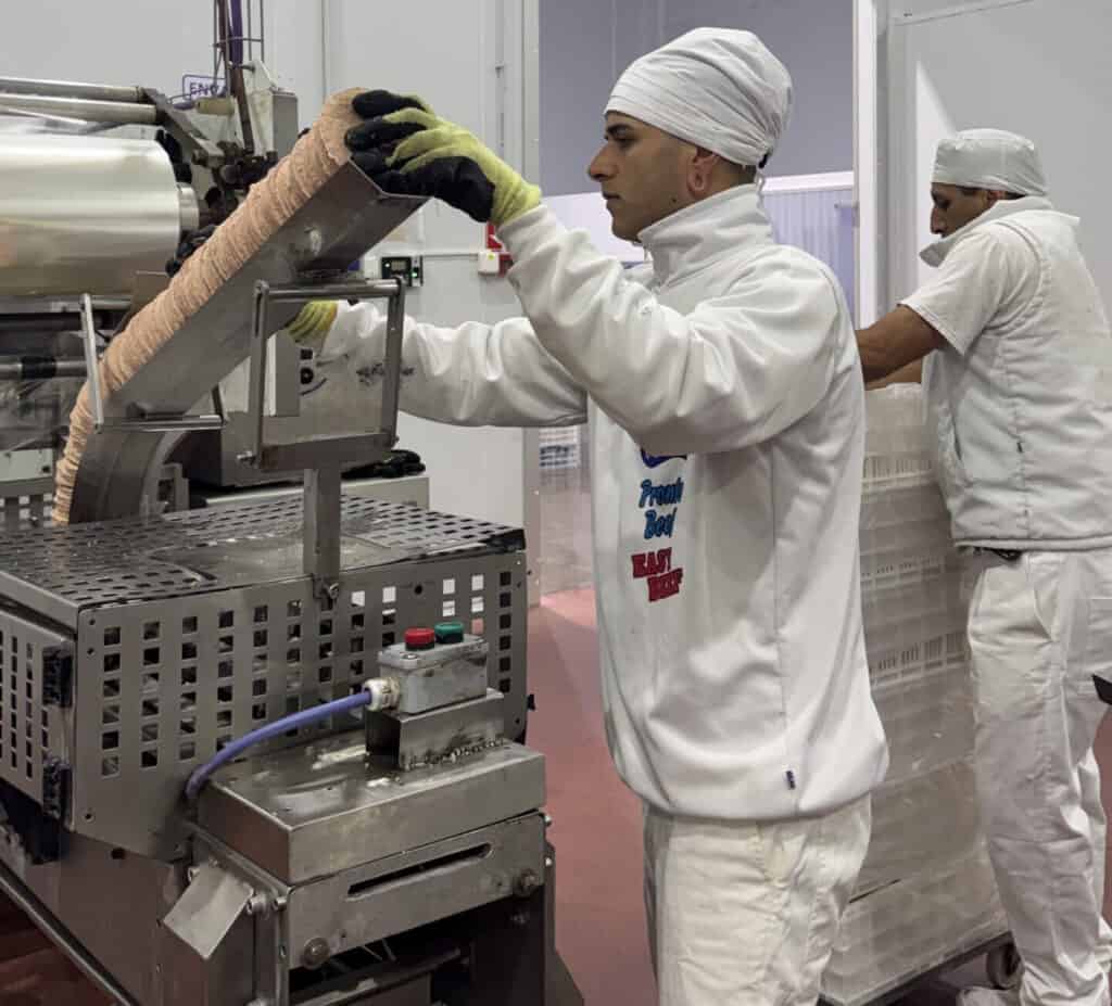 Operario de Aquatro alimentando la formadora de medallones de hamburguesas Pronto Beef y MaxiMesa