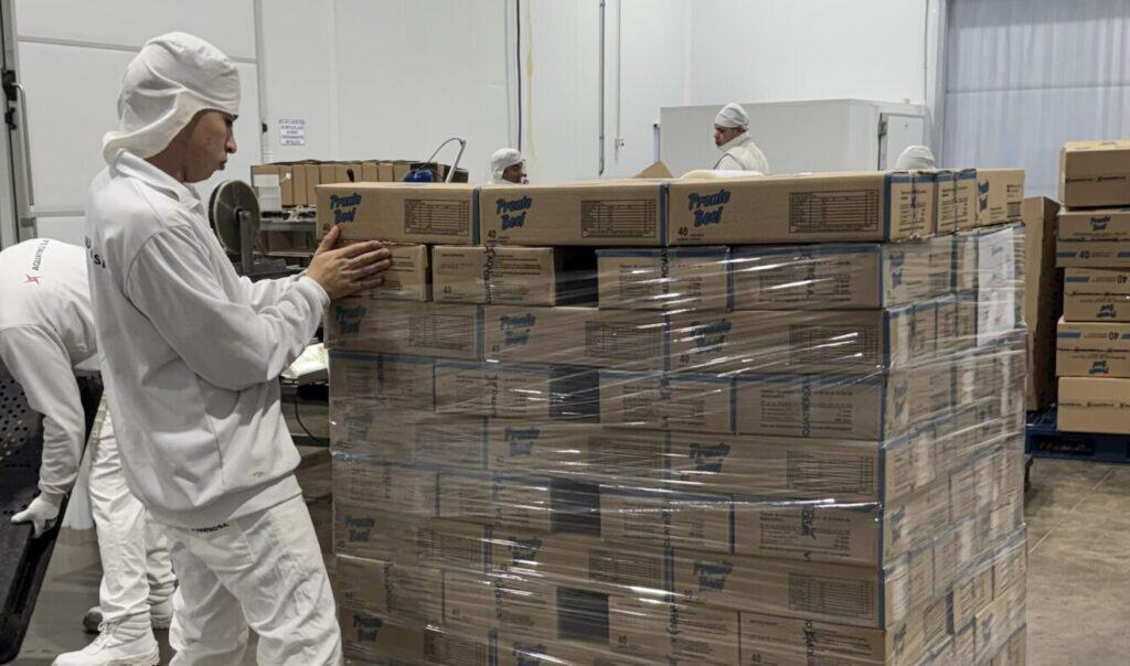 Operario de Aquatro acomodando pallets de hamburguesas en depósito mayorista